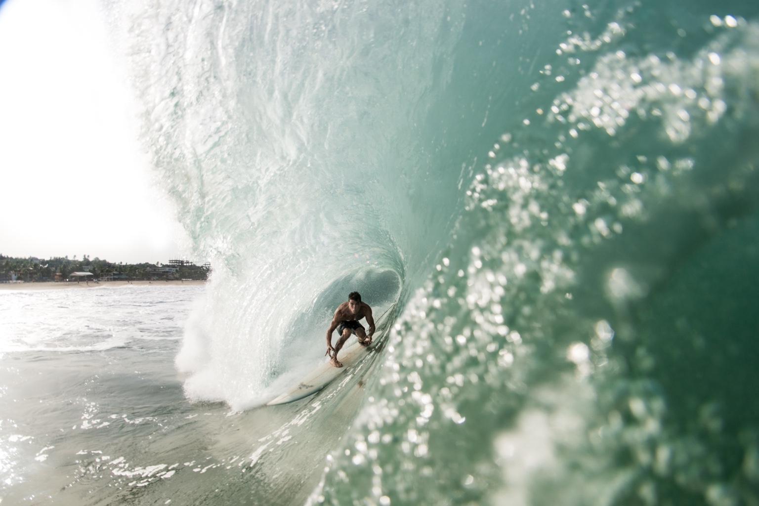 Fabiano surfando dentro de um tubo, visto de perto da parede da onda